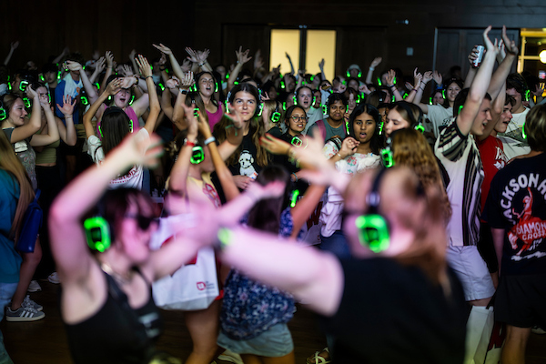 Students wear illuminated headphones and dance to a “silent disco party” during the Sunburst Festival