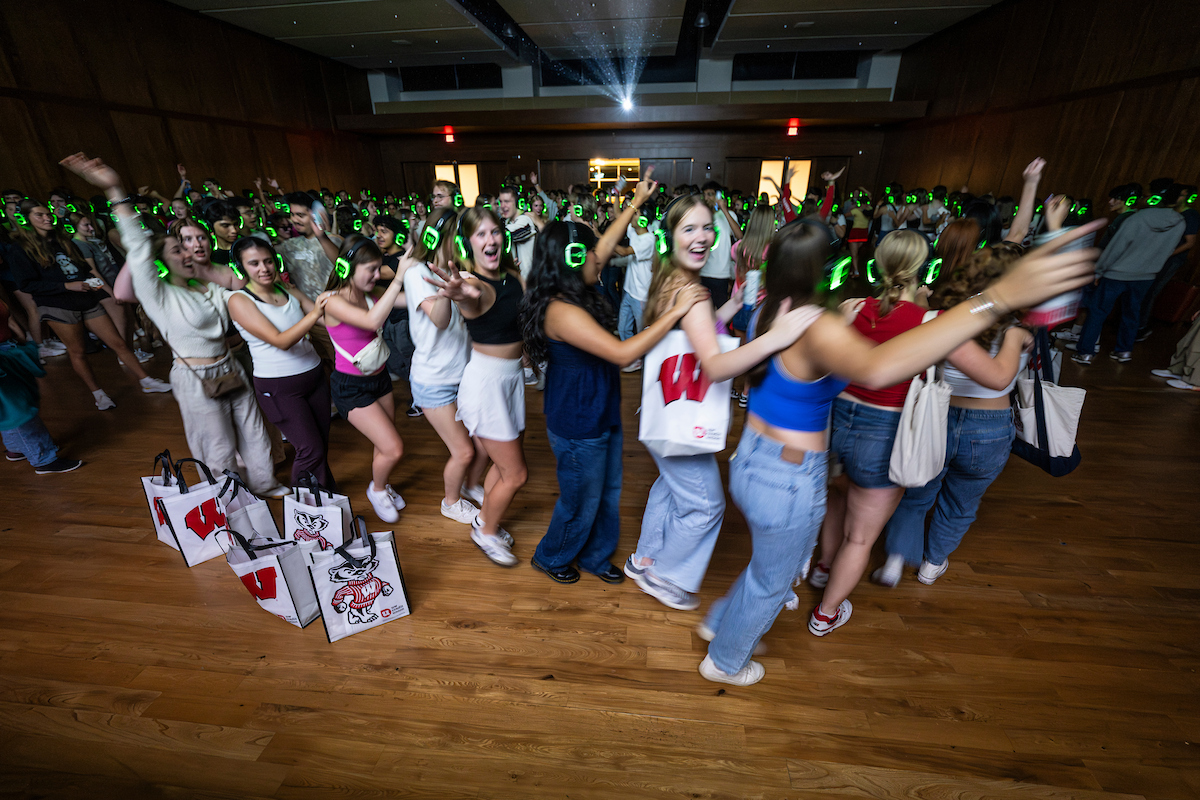 Students wear illuminated headphones and dance to a “silent disco party” during the Sunburst Festival at Union South.